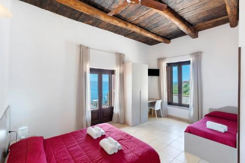 a bedroom with a red bed and some windows at Tenuta Donna Carmela in Pisciotta