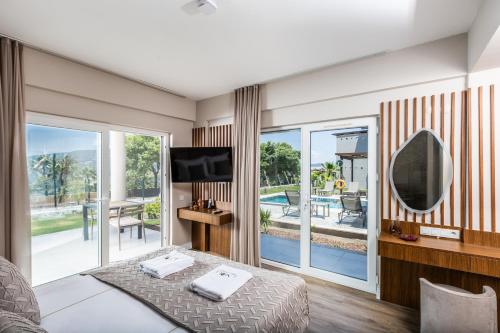 a room with a bed and a tv and a balcony at Unique Residence Hotel Golf and Spa in Soke