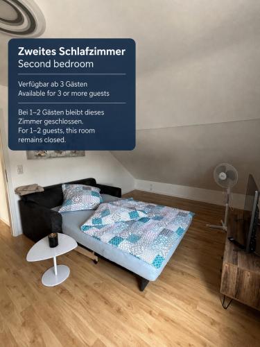a bed in a room with a sign on the wall at Ferienwohnung Zentral in Lörrach - KONUS Gästekarte inklusive in Lörrach
