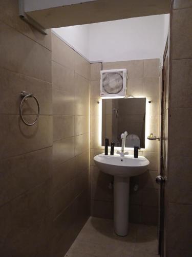 a bathroom with a white sink and a mirror at The Elet Express Luxury Hotel Apartments in Karachi
