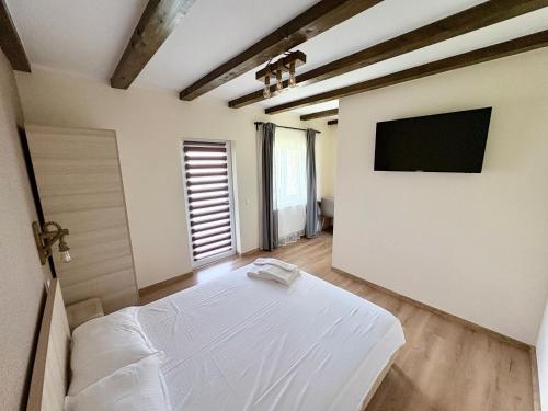 a bedroom with a bed and a flat screen tv at Casa Magda - Oaza de Relaxare in Călimăneşti