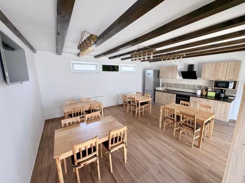 a kitchen with wooden tables and chairs in a room at Casa Magda - Oaza de Relaxare in Călimăneşti