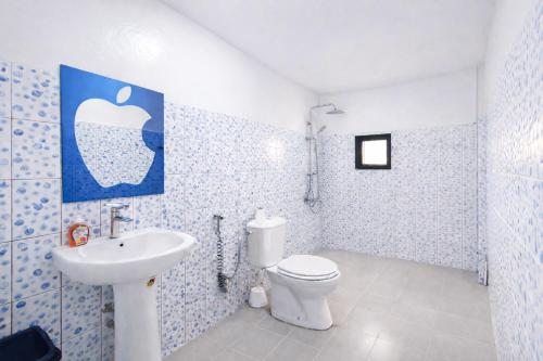 a bathroom with a white toilet and a sink at Résidence Senghor - THIÈS in Thiès