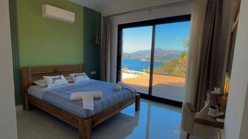 a bedroom with a bed with a view of the ocean at Villa Han Selimiye in Selimiye