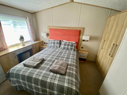 a bedroom with a bed with two towels on it at Debran Lodge in Angus