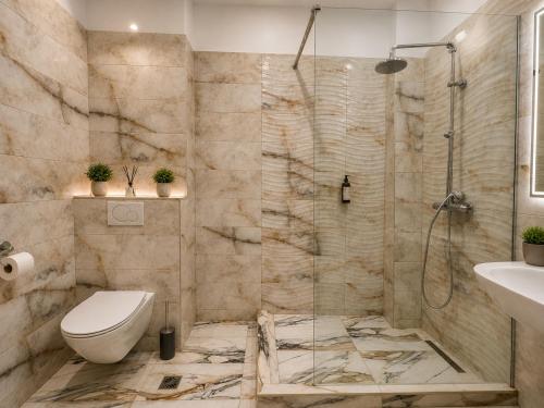 a bathroom with a shower and a toilet and a sink at Coralia Luna Park Apartments in Mamaia