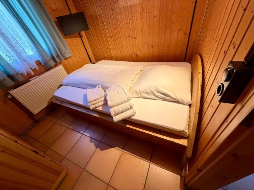 a small bed in a wooden room with towels on it at Jagdhütte in Zöllnitz