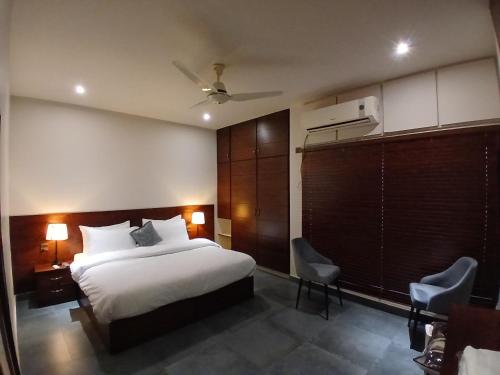a hotel room with a bed and a chair at The Elet Express Luxury Hotel Apartments in Karachi