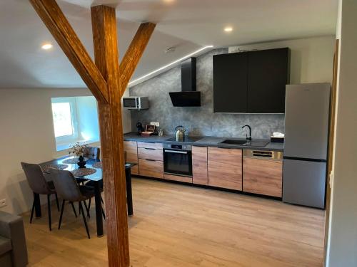 a large kitchen with a table and a refrigerator at Apartmány Branná hodnocení 10 Wellness Vleky 5 min in Horní Branná