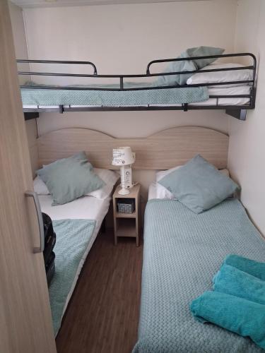 two beds in a small room with bunk beds at Mobillehome Camp Turanj in Turanj