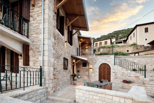 a stone house with a patio and a wooden door at Valaes Guest House in Foiníkion