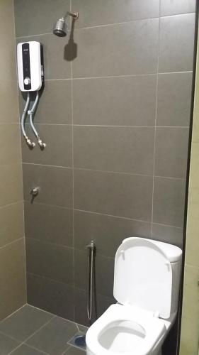 a bathroom with a toilet and a phone on the wall at Mass Hotel in Kampong Kerayong