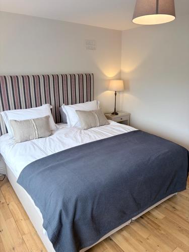 a bedroom with a large bed with a blue blanket at Murreigh Beag Waterville in Waterville