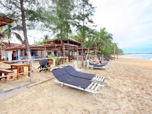 a beach with lounge chairs and people laying on them at Beach Cab Resort in Arugam Bay