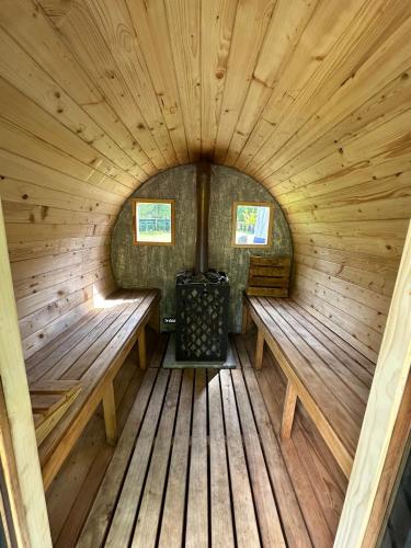 an inside view of a wooden sauna with two benches at Slow Flow Glamp - sauna, basen i jacuzzi in Rzyki
