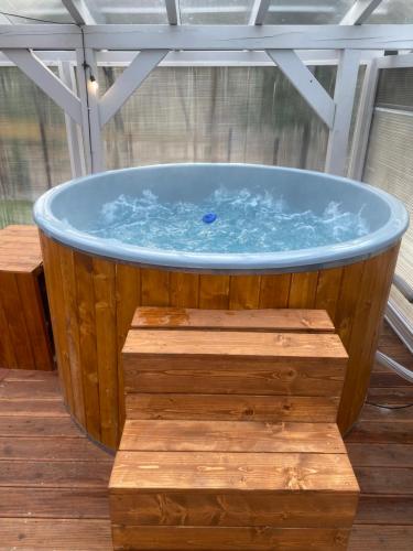 a large wooden tub sitting on top of a table at Slow Flow Glamp - sauna, basen i jacuzzi in Rzyki
