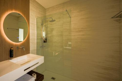 a bathroom with a shower and a sink and a mirror at Moinho do Canto Residence Hotel in Rio Maior