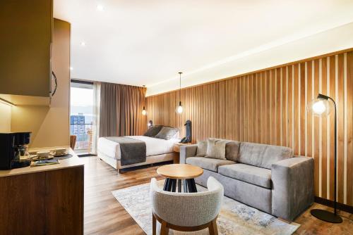 a living room with a couch and a bed in a room at Blues Suites Medellín in Medellín