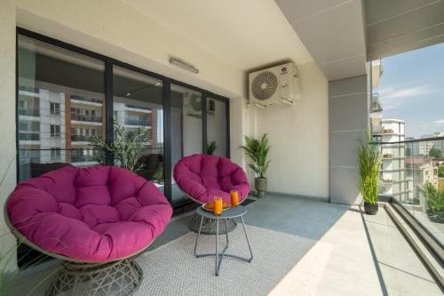 a balcony with two chairs and a table at Celeste Apartment 2BDR Parking in Bucharest