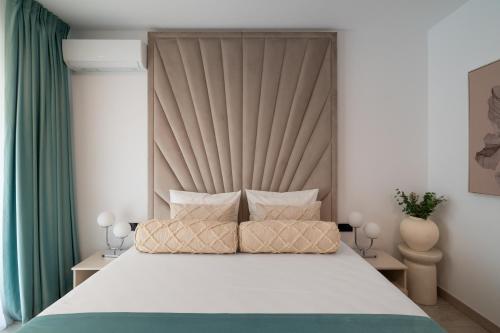 a bedroom with a large bed with a large headboard at Celeste Apartment 2BDR Parking in Bucharest