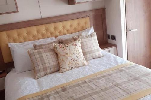 a bedroom with a bed with pillows on it at 2-Bed Cabin - Sleeps 5 - Parking - Pet Friendly in Carnforth