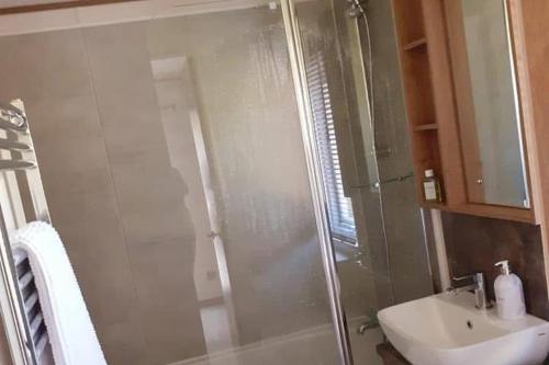 a bathroom with a glass shower and a sink at 2-Bed Cabin - Sleeps 5 - Parking - Pet Friendly in Carnforth