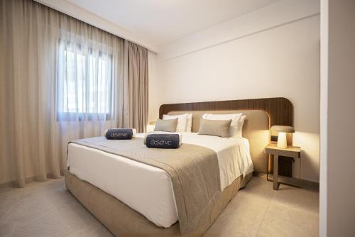 a bedroom with a large bed with two towels on it at Avenue by Deserve in Paphos