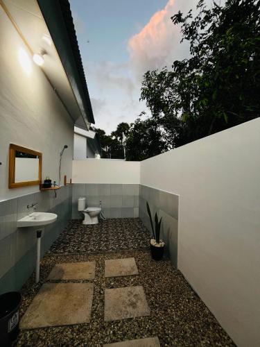 a bathroom with a toilet and a sink at Lomba Oen bungalow in Nembrala