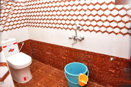 a bathroom with a toilet and a bucket at Dharani Residency in Pondicherry