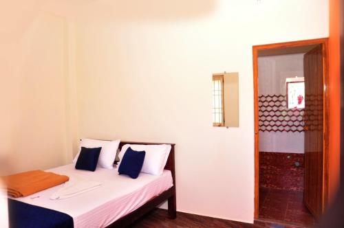 a bedroom with a bed with blue and white pillows at Dharani Residency in Pondicherry