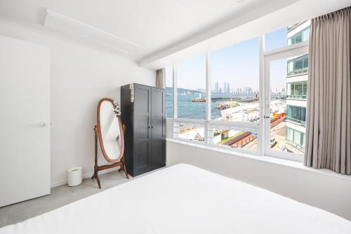a bedroom with a bed and a large window at 지니스테이 in Millak-tong