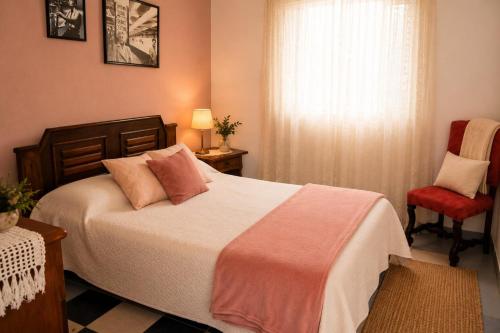 a bedroom with a bed and a red chair at Fazenda Monte Verde a Morada do Muriqui in São Francisco Xavier