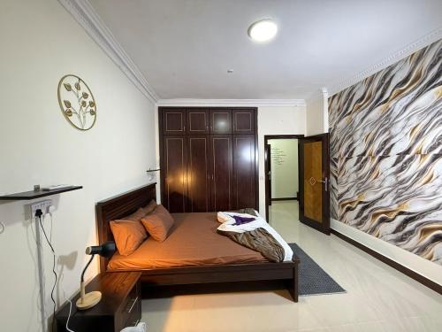 a bedroom with a bed and a fish painting on the wall at Unmatched Location - A Large 2BR Sea-facing Flat in Sharjah