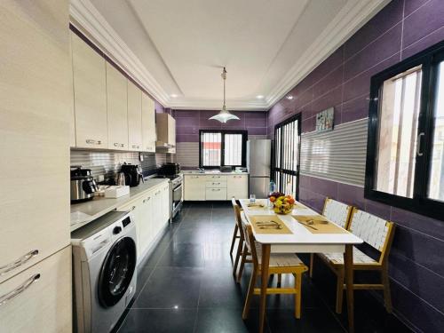 a kitchen with purple walls and a table and chairs at Chez sesa in Dakar
