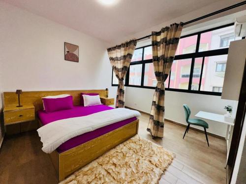 a bedroom with a bed with purple sheets and a chair at Chez sesa in Dakar
