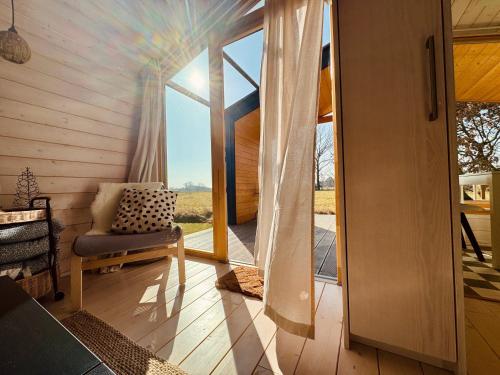 a room with a sliding glass door and a chair at 204 Hochwertiges Tiny House mit Wiesenblick in Bleckede