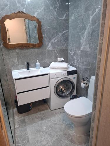 a bathroom with a washing machine and a toilet at SV Apartment in Jõhvi