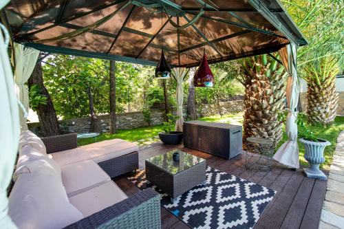 a pergola with a couch and a table at Villa Euphoria in Theológos