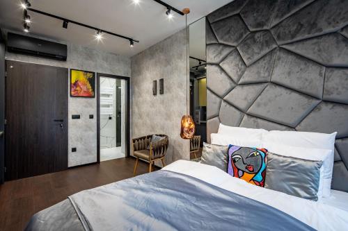 a bedroom with a large bed and a stone wall at Super Central - Modern & Luxury in Budapest