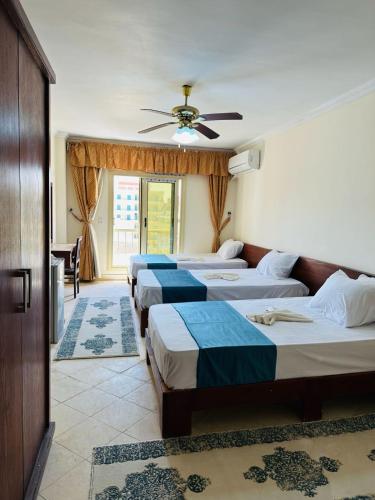 a group of four beds in a room at Bianco Matrouh Hotel in Marsa Matruh