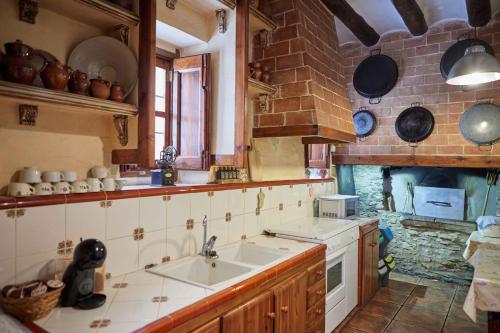 a kitchen with two sinks and pots and pans at Masía El Losar - Casa Rural Exclusiva Castellón in Villafranca del Cid