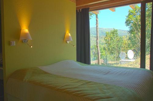 a bedroom with a bed and a window with a view at Retiro Da Arminda in Canedo