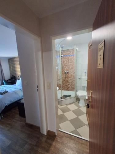 a bedroom with a bathroom with a toilet and a shower at STEP IN Apartments ! in Wilhelmshaven