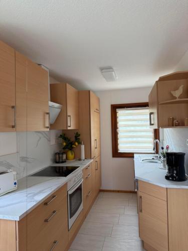 a large kitchen with wooden cabinets and a window at Ferienhäuser Holenberg in Holenberg
