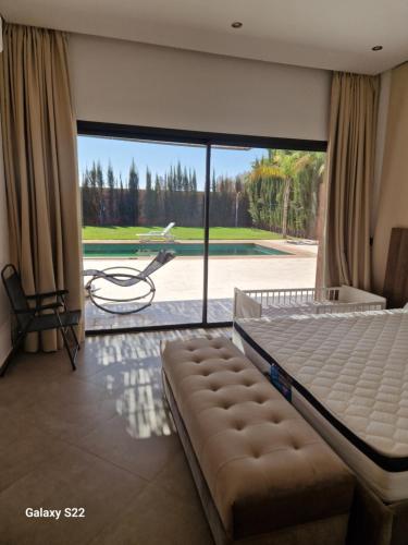 a bedroom with a bed and a view of a pool at Agadir sans vis a vis in Bouria