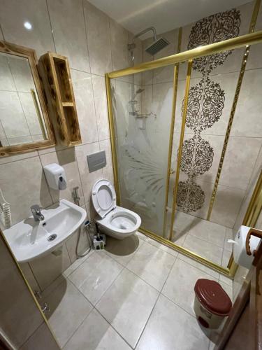 a bathroom with a shower and a toilet and a sink at Osmanlı Suite in Uzungöl