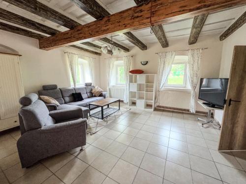 a living room with a couch and a tv at Apartmán 56 in Božanov