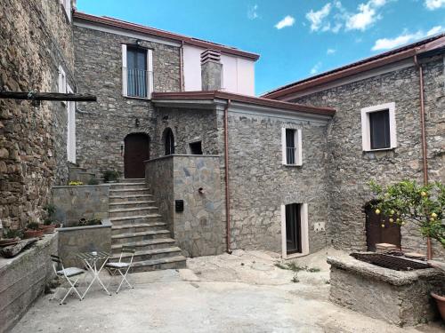 a stone building with stairs and chairs in front of it at Tredici lune B&B in Finocchito