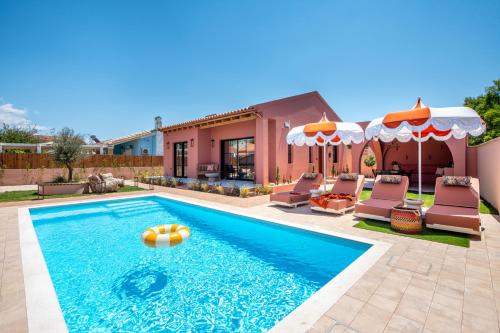 a swimming pool with chairs and a house at Casa Tortuga - Exclusive Villa Corfu in Acharavi