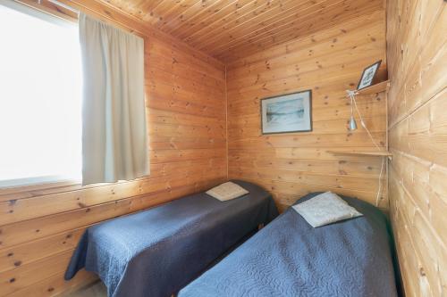 a bedroom with two beds in a wooden cabin at Ailakka, huoneisto A in Kilpisjärvi